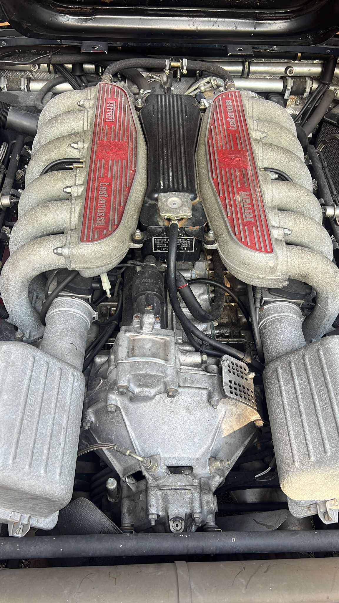 A close up of a car engine with red exhaust pipes.