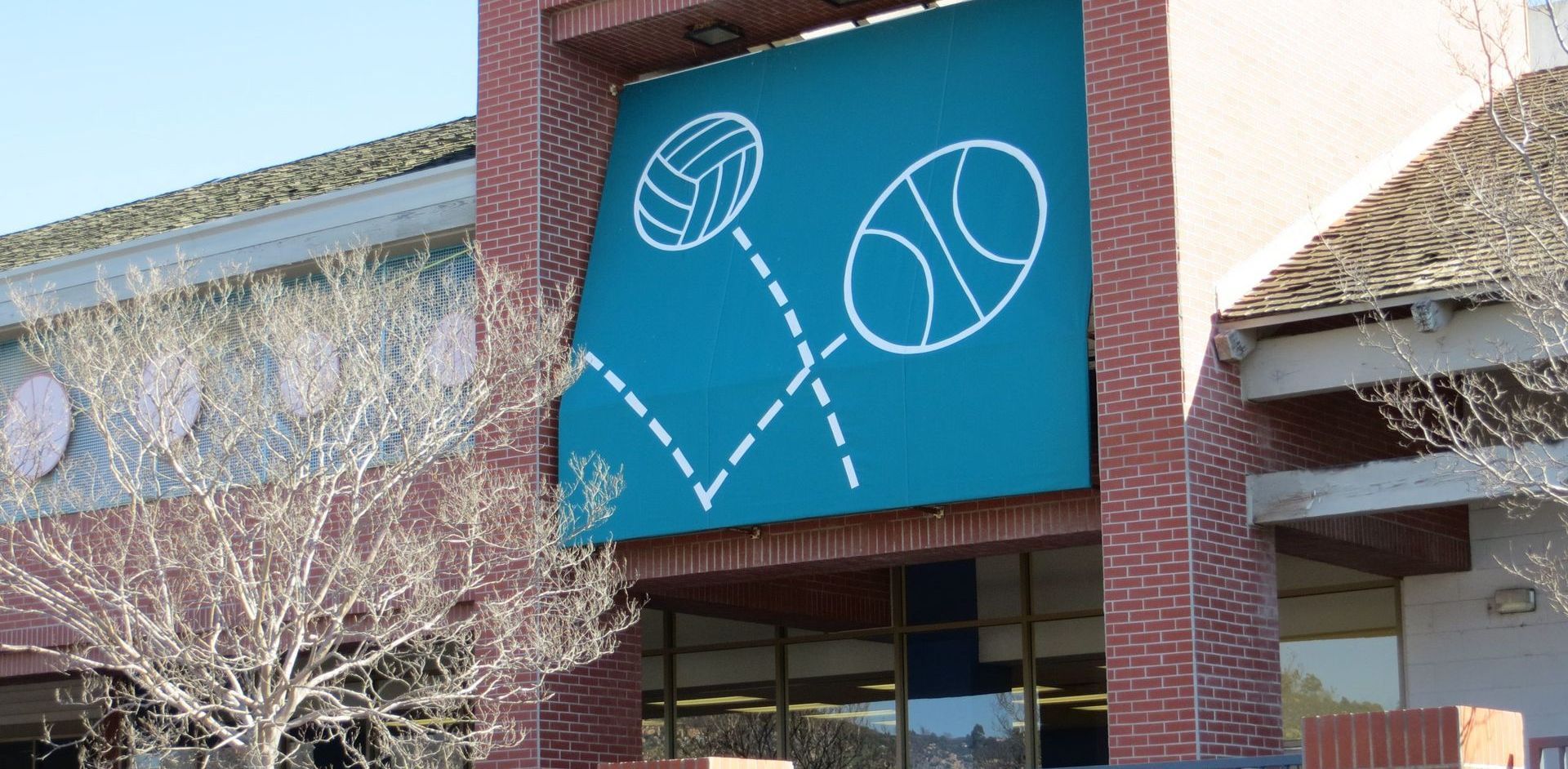 A building with a sign that says volleyball and basketball on the awning