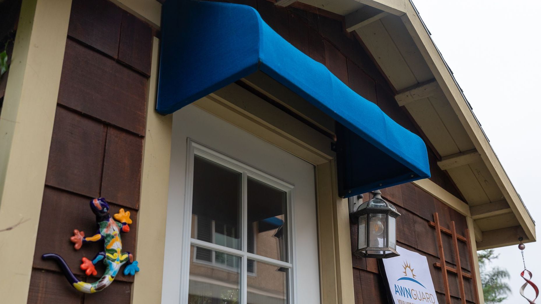 A blue awning is on the side of a house