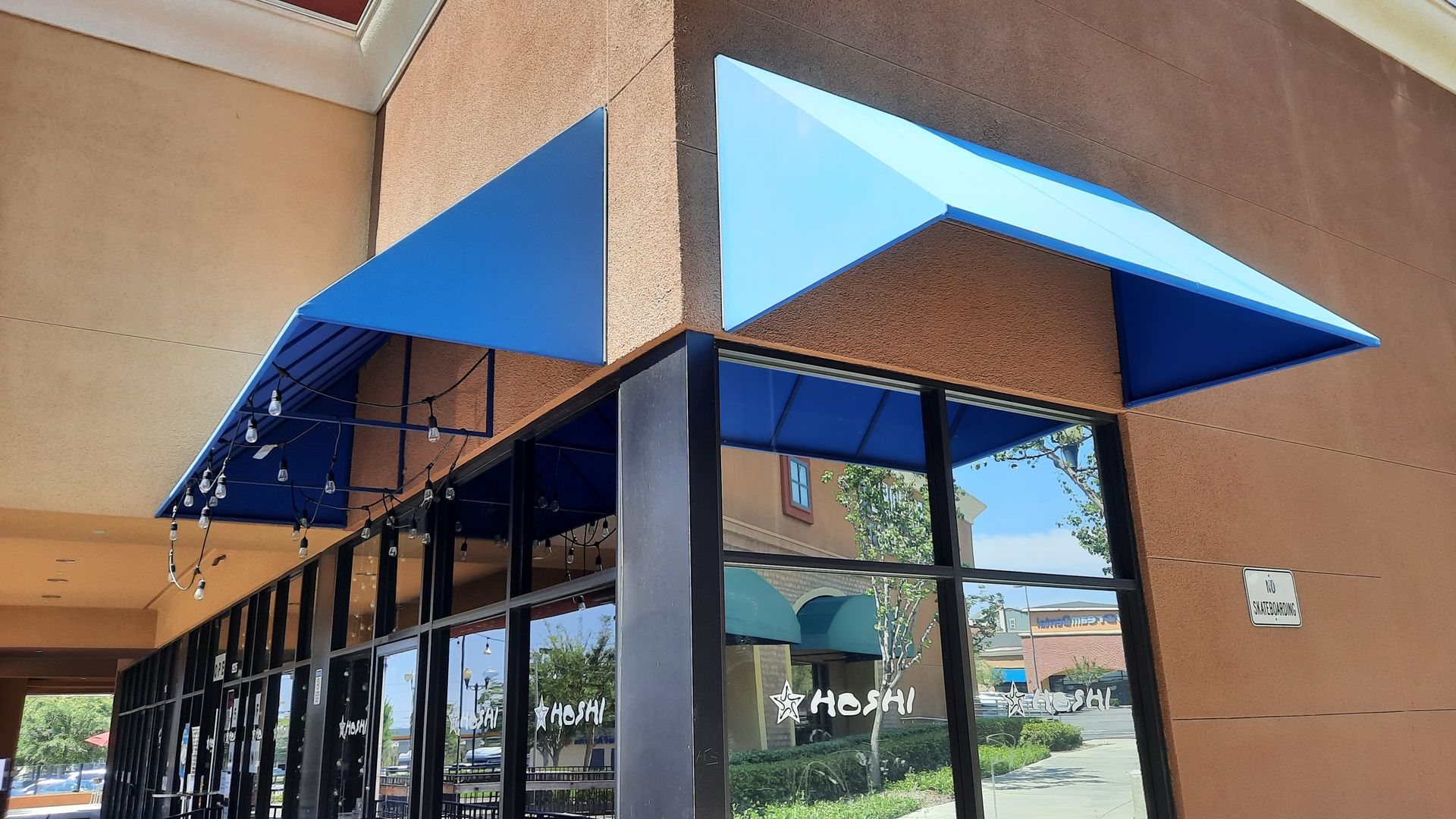 Two blue awnings on corner of building