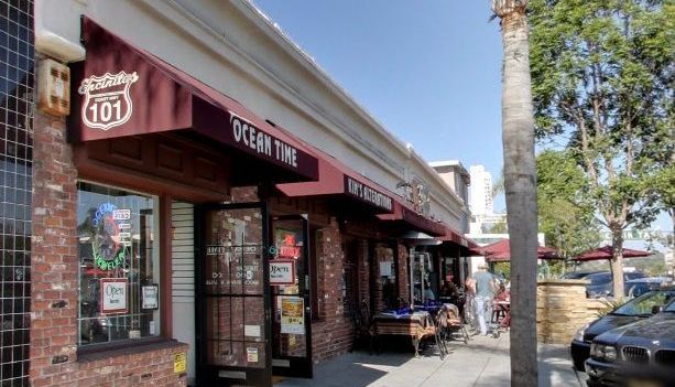 A brick building with a red awning that says ocean time.