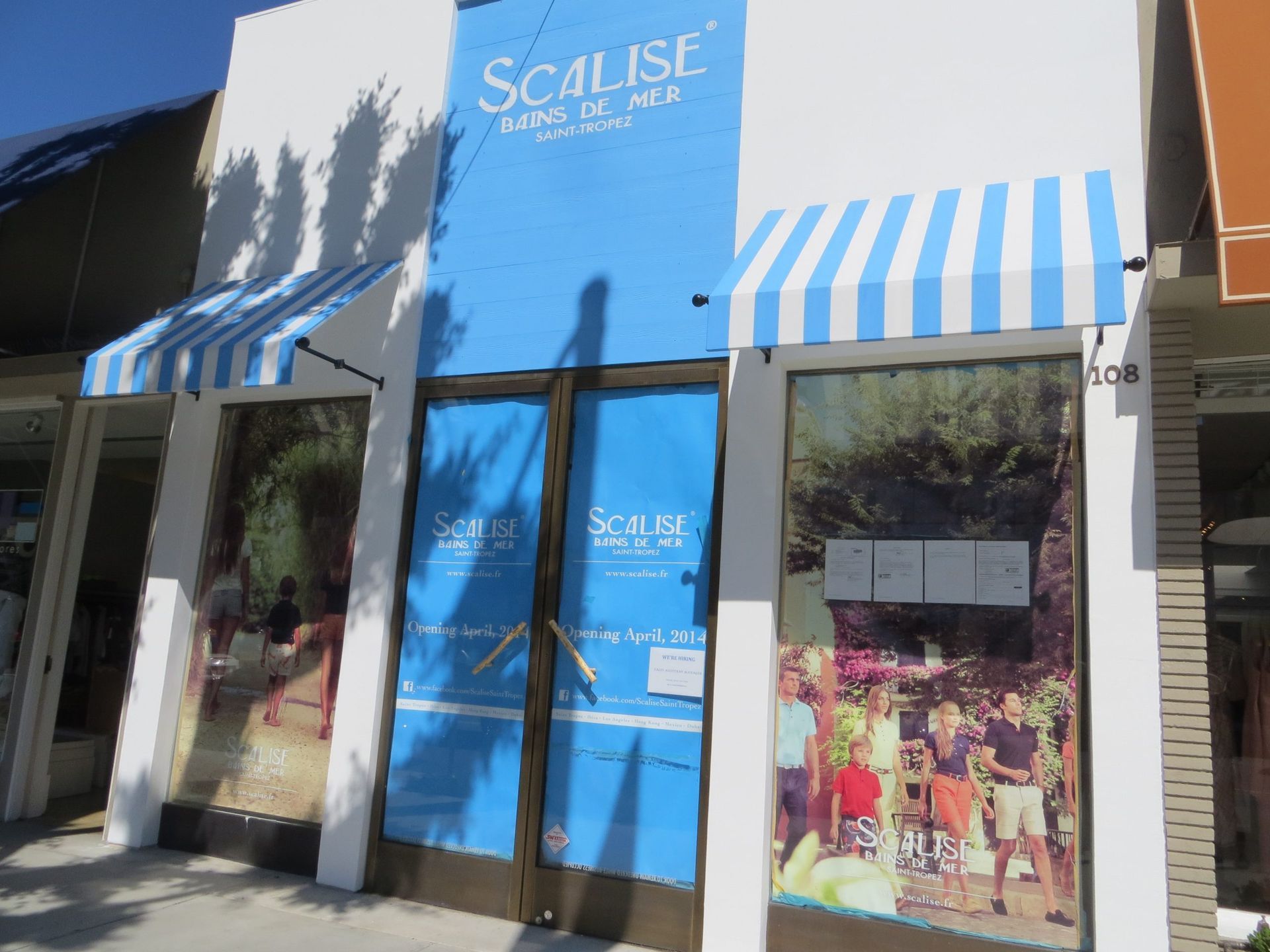 A blue and white striped awning is on the front of a scalise store