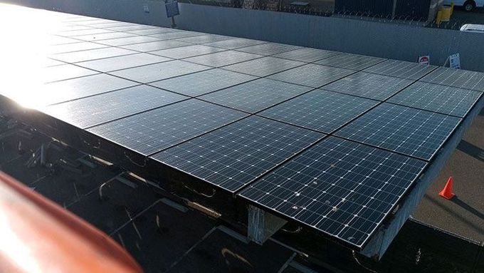 A row of professionally cleaned solar panels on top of a building