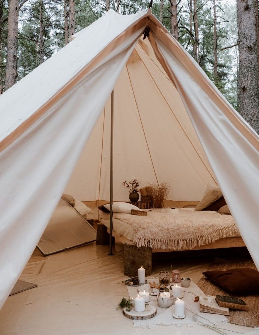 A tent with a bed and candles inside of it