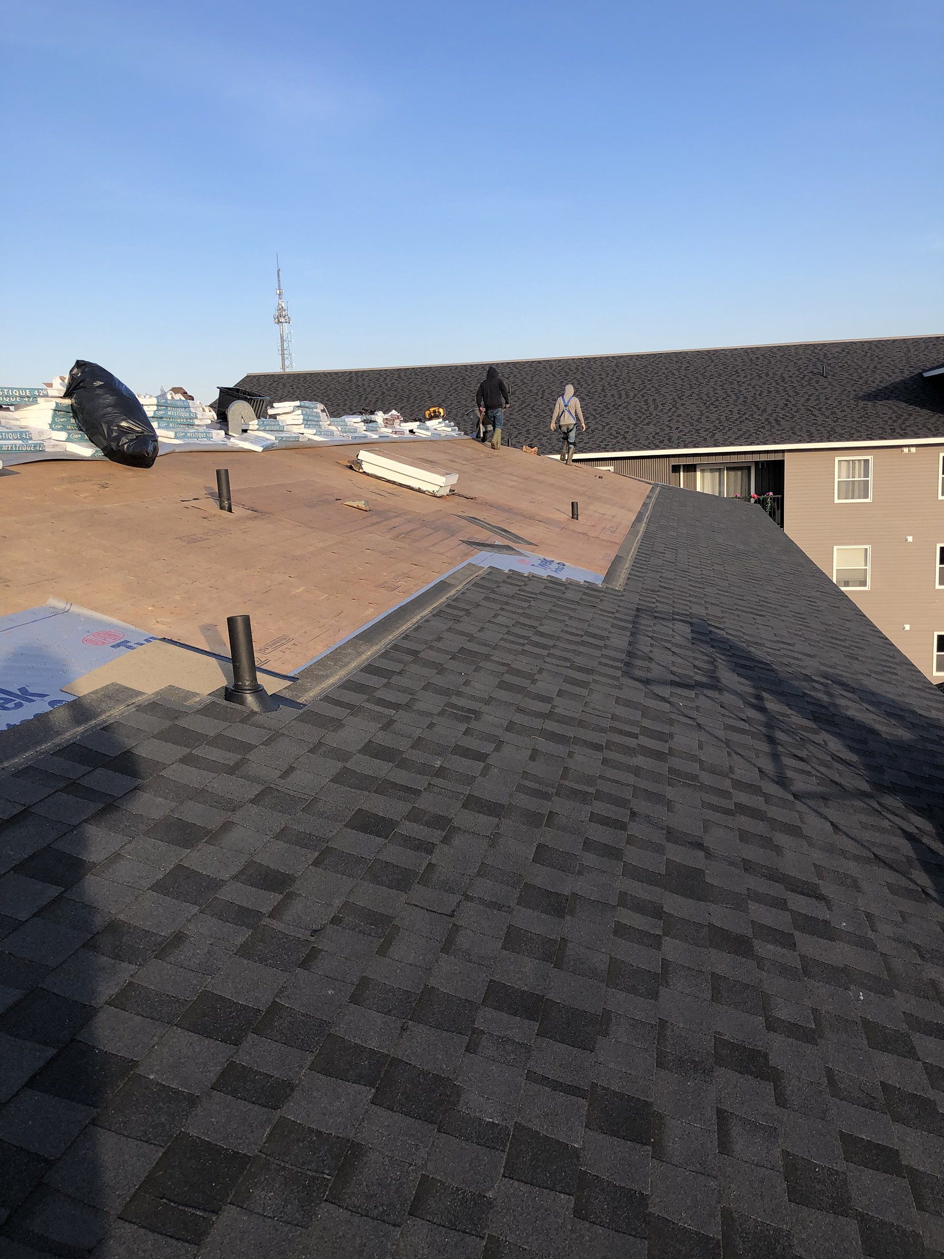 A roof with shingles on it is being installed on top of a building.