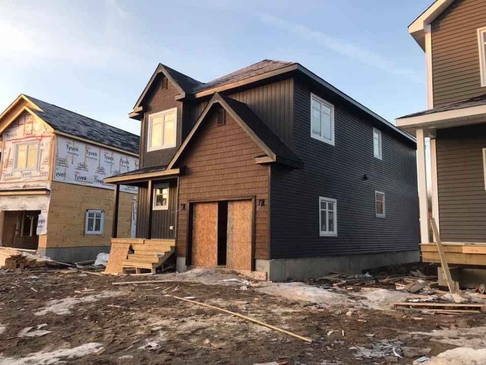 A house is being built in the middle of a dirt field.