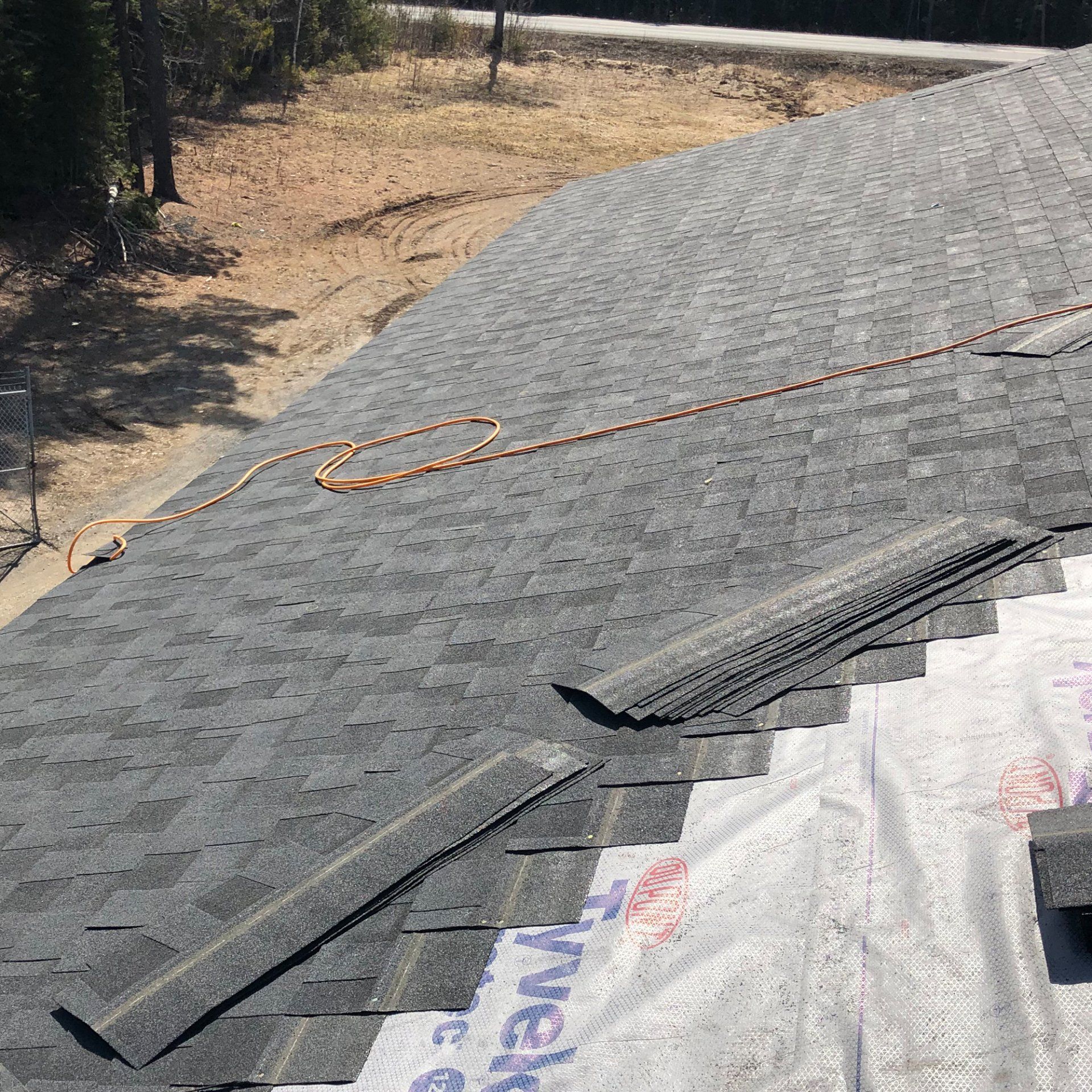 A roof with shingles being installed on it is being worked on.