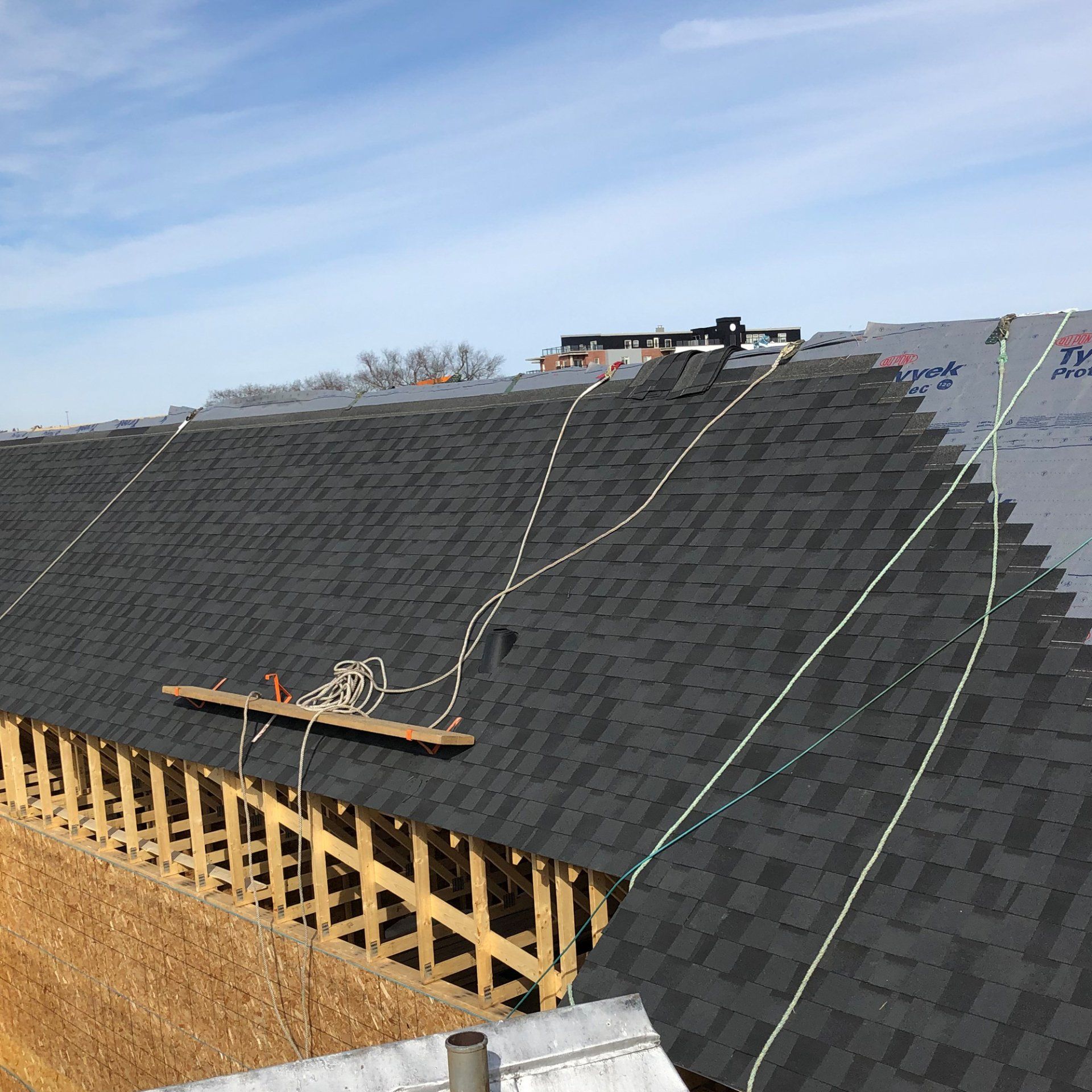 A large roof with shingles being installed on it
