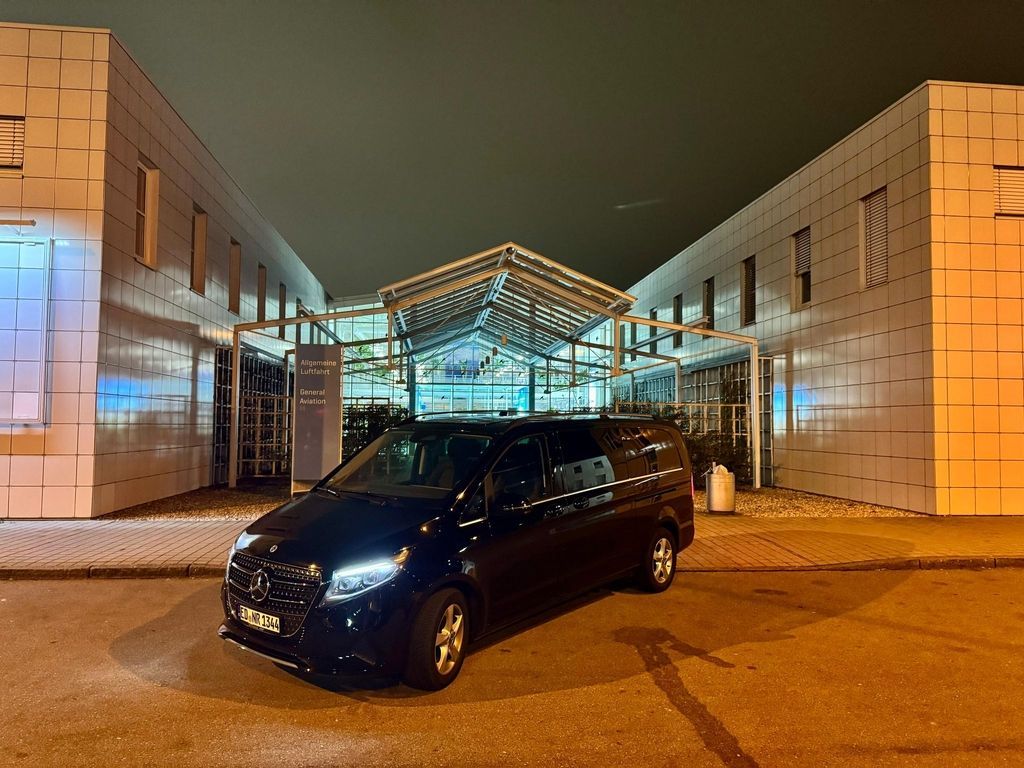 Schwarzer Business Van vor dem Terminaleingang am Flughafen München