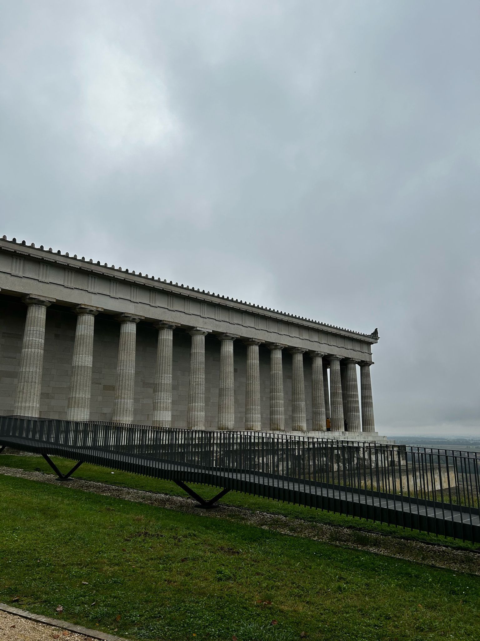 Ein großes Gebäude mit Säulen und einer Brücke davor
