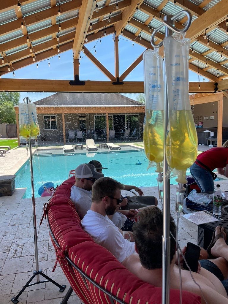 A group of men are sitting on a couch in front of a pool.