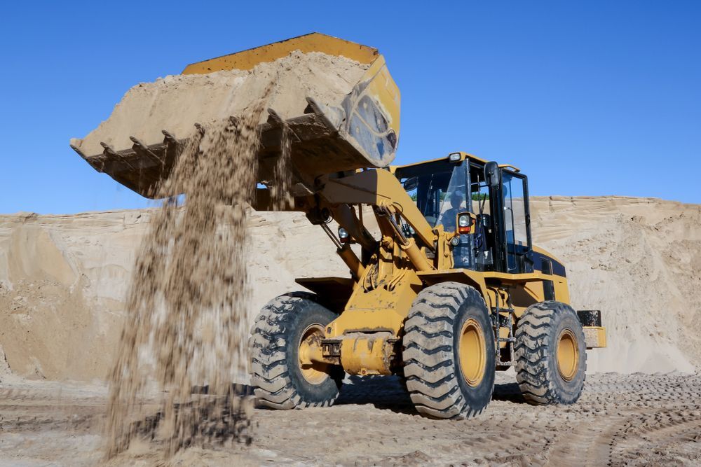 A Bulldozer is Pouring Sand Into a Pile — Wilsons Plant in Appin, NSW