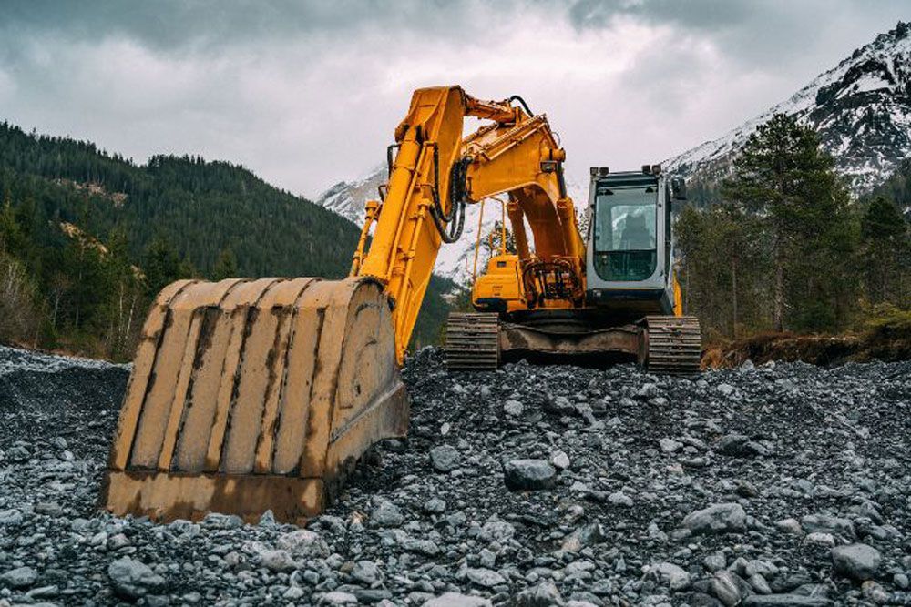 Excavator Operating On Rocky Construction Site