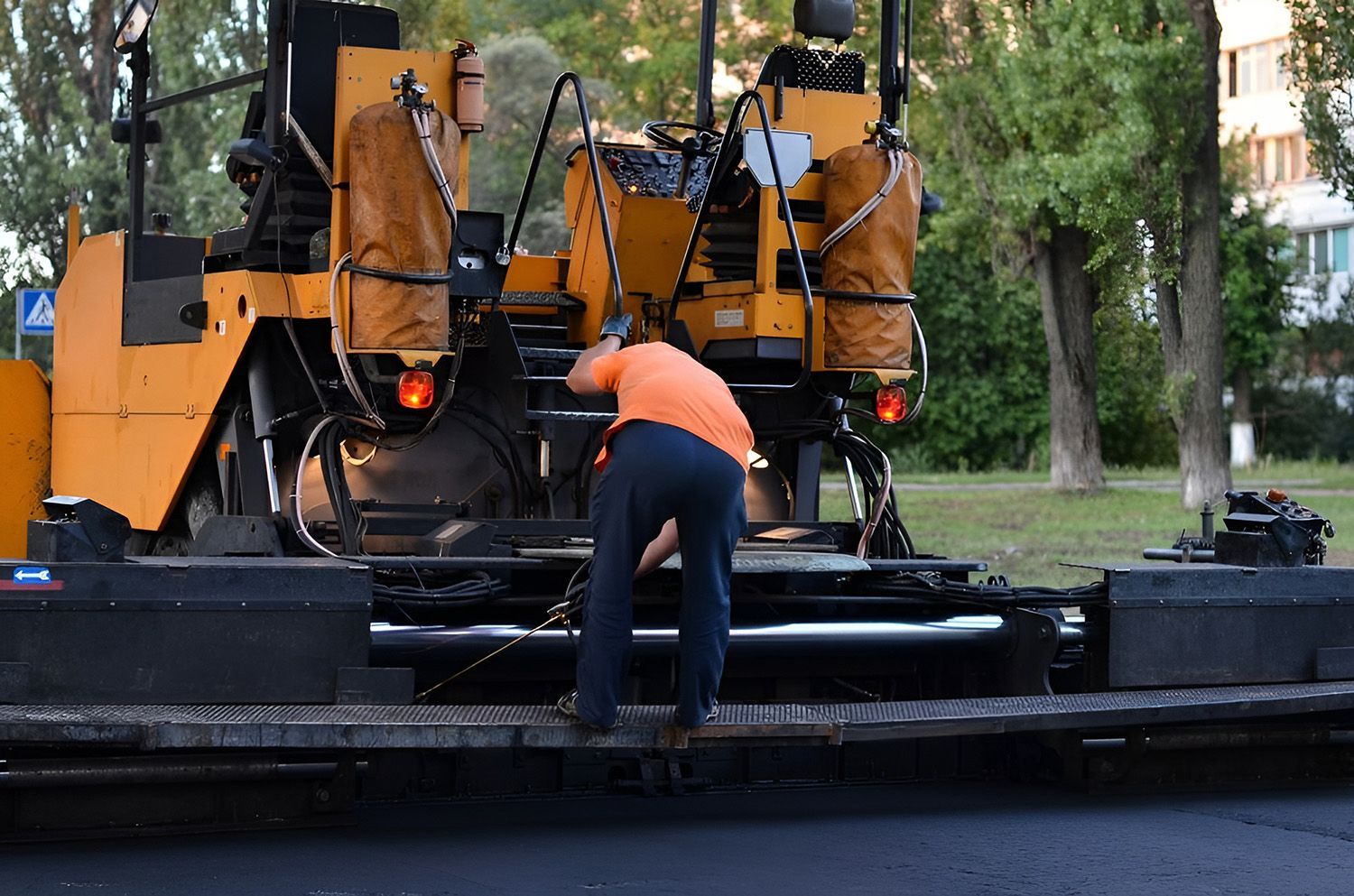 On-Site Heavy Machinery Repair Technician Servicing Road Paving Equipment