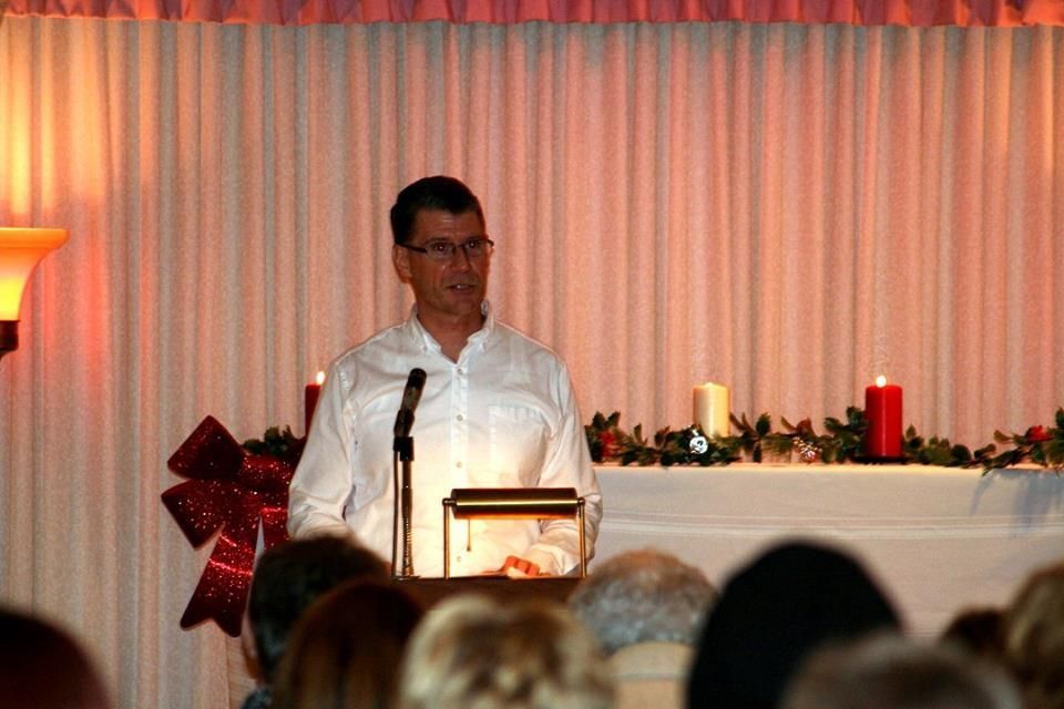 a man is standing at a podium giving a speech in front of a crowd .