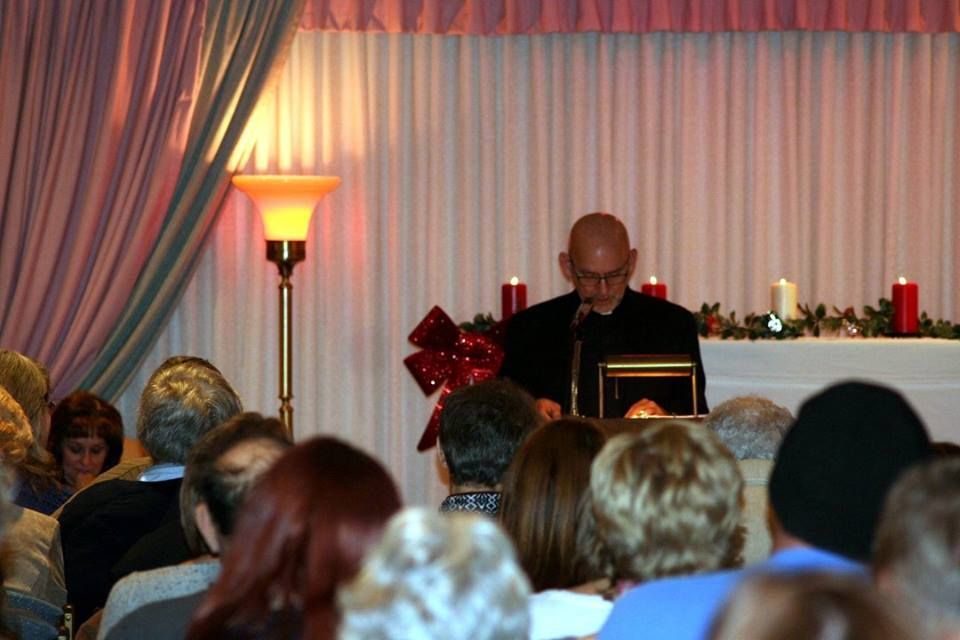 a man is giving a speech in front of a crowd of people