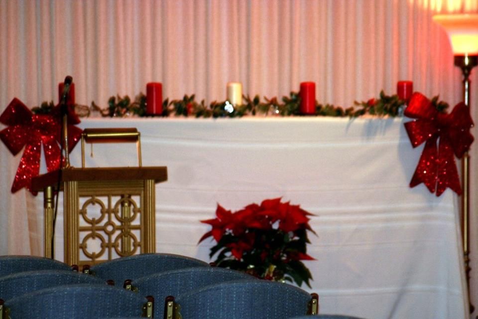 a church with a podium and chairs decorated for christmas