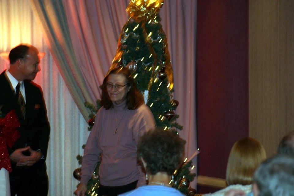a group of people standing in front of a christmas tree