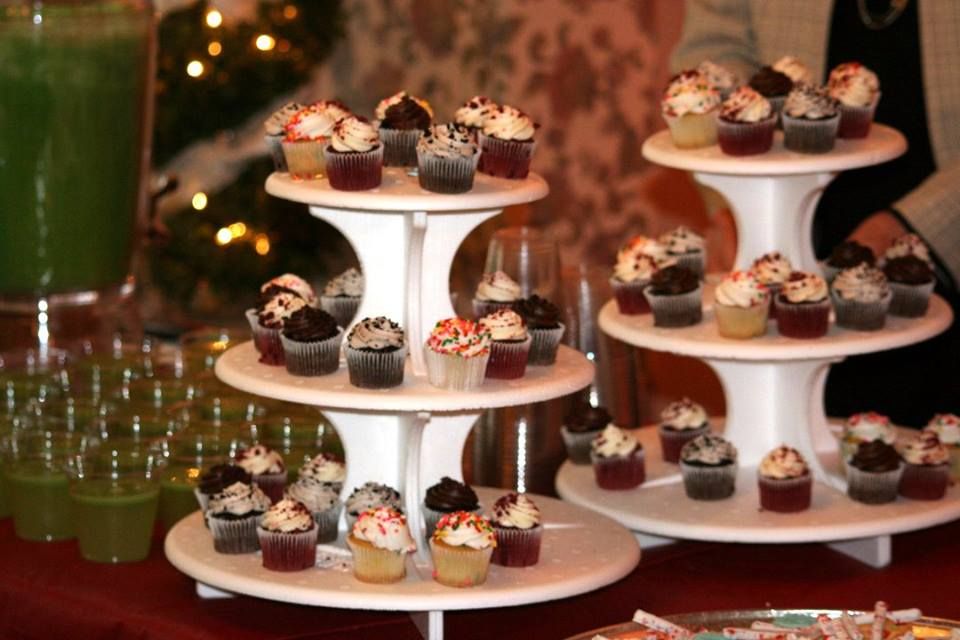 a cupcake tower filled with cupcakes on a table