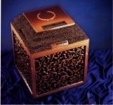 a square urn vault with a square lid is sitting on top of a blue cloth .