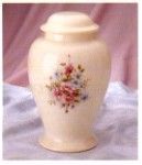 a white urn with flowers painted on it is sitting on a table .