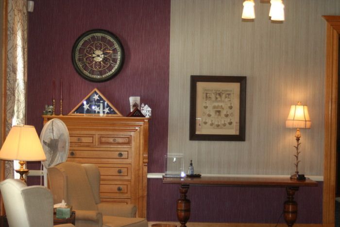 a living room with purple walls and a clock on the wall
