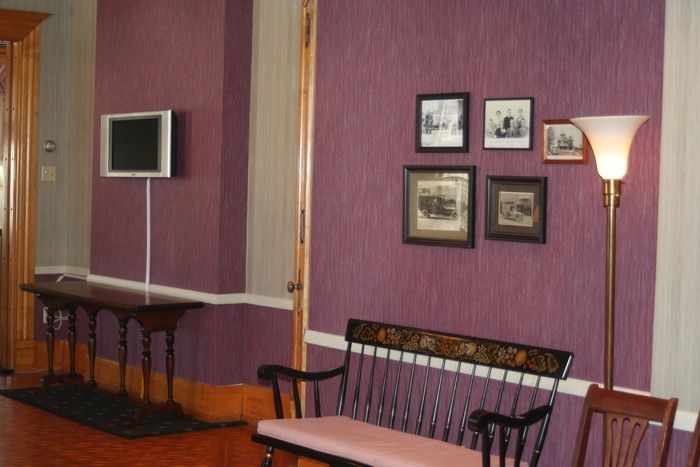 a living room with purple walls and pictures on the wall