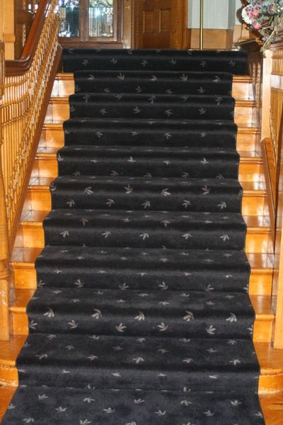 a set of stairs with a black carpet on them