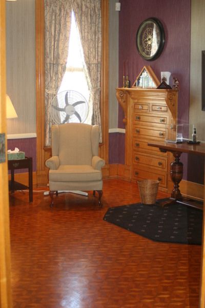 a living room with a chair and a dresser