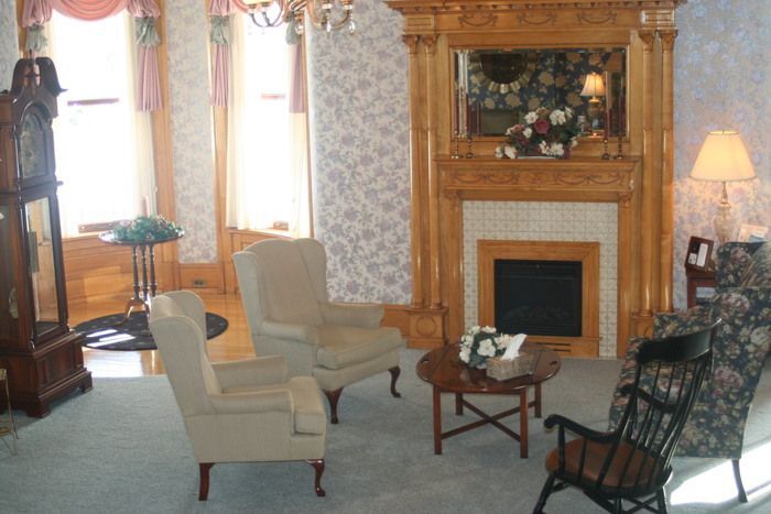 a living room with a fireplace and chairs