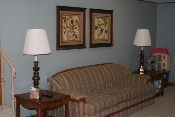 a living room with a striped couch and two lamps