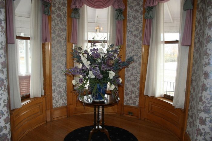 there is a vase of flowers on a table in a room .