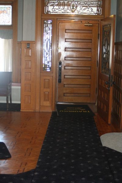 a hallway with a wooden door and a stained glass window