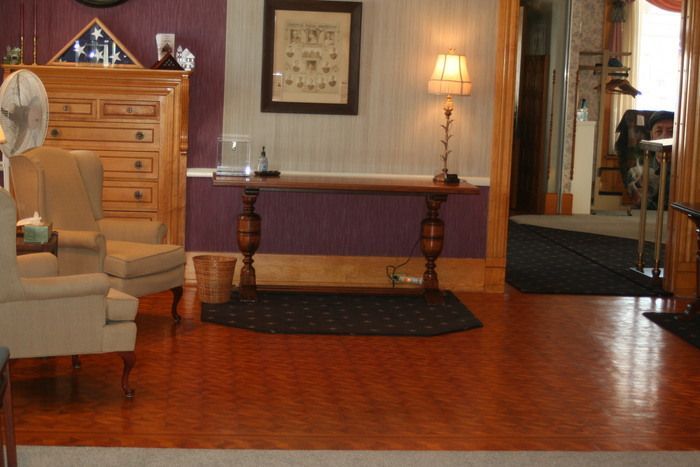 a living room with chairs a table and a lamp