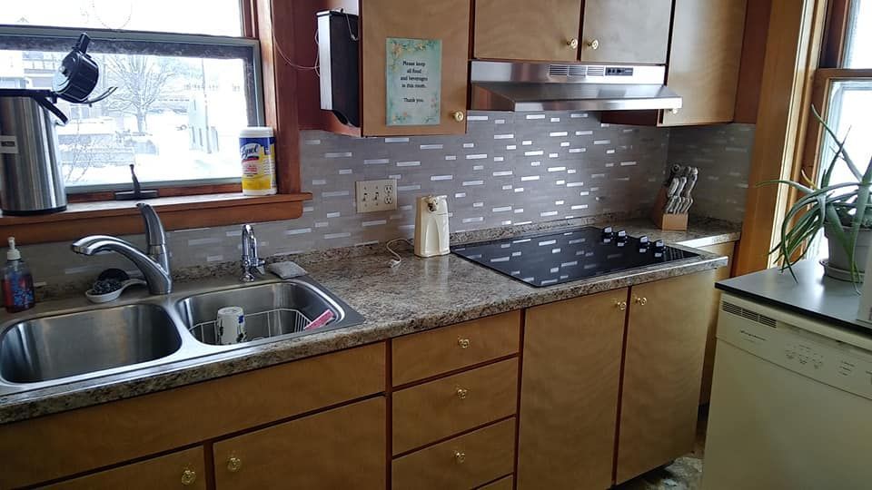 a kitchen with a sink , stove , and window .