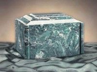 a green marble urn is sitting on top of a table .