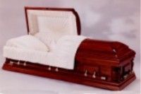 a wooden casket with the lid open and a white blanket on it .