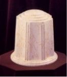 a white urn is sitting on top of a red table .