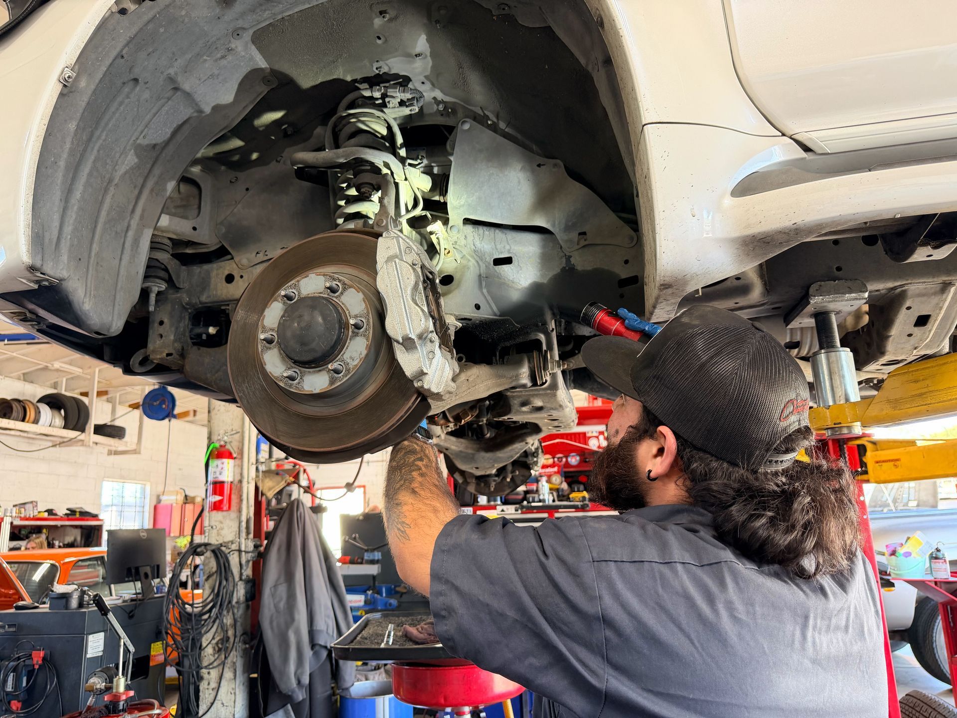 Technician inspecting vehicle suspension for shaking issue at Wayside Garage in Seaside CA