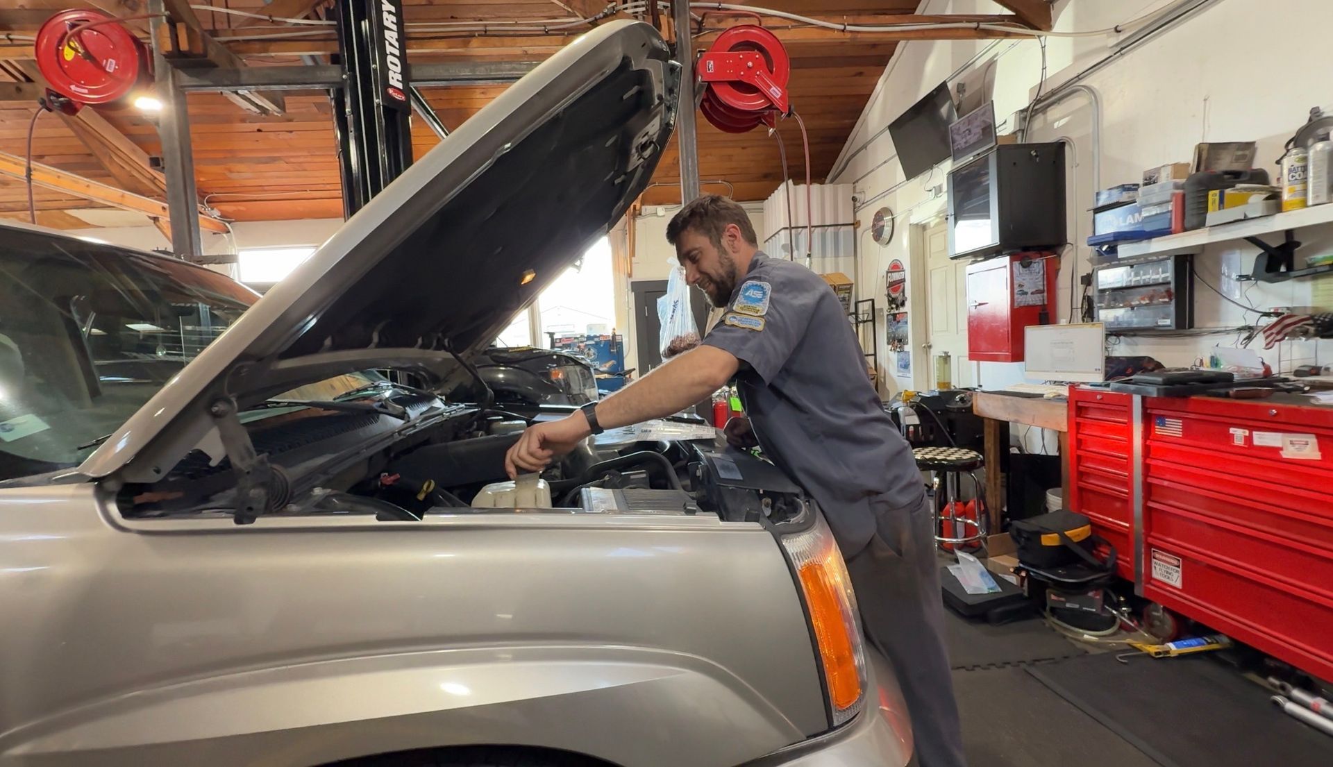 Technician inspecting vehicle cooling system and coolant reservoir at Wayside Garage in Seaside CA