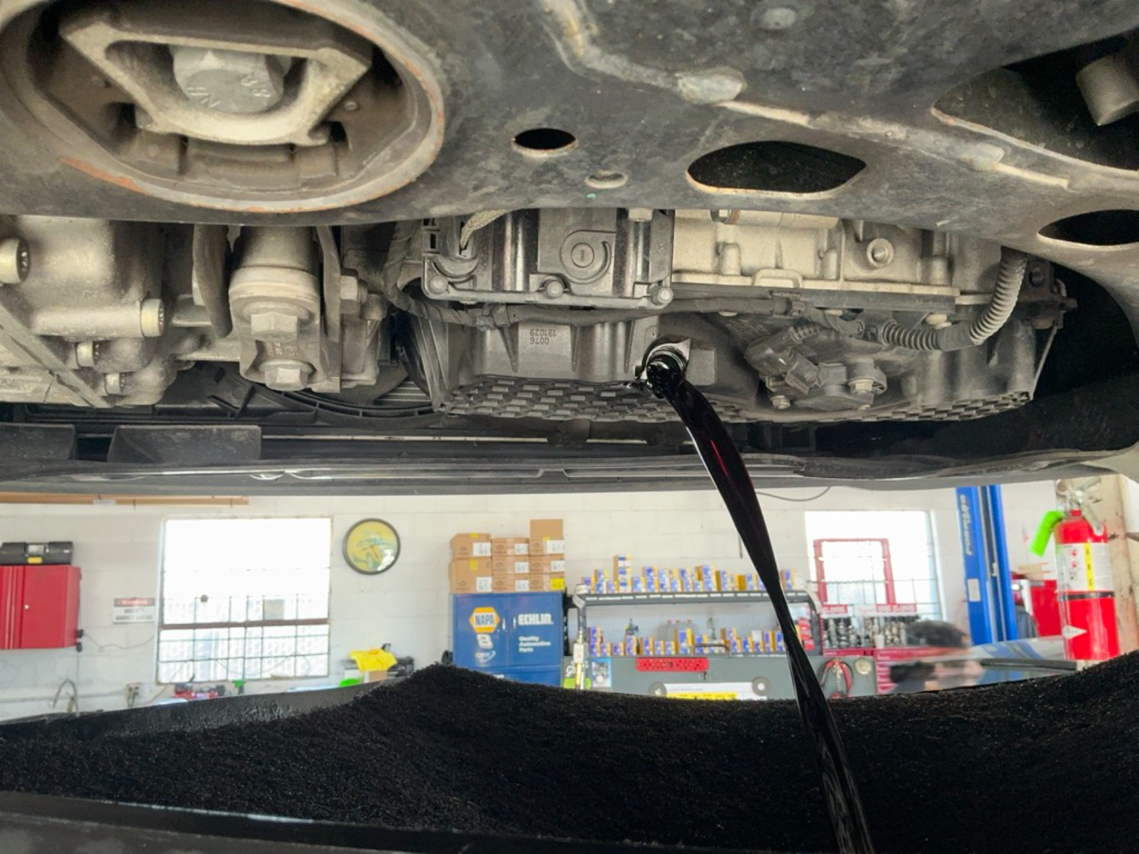 Engine oil draining during oil change service at Wayside Garage in Seaside CA