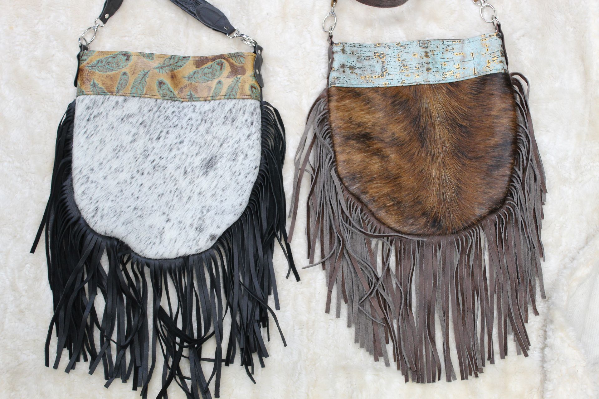 Two fringed crossbody bags, one black and one brown, with textured leather and patterned tops.