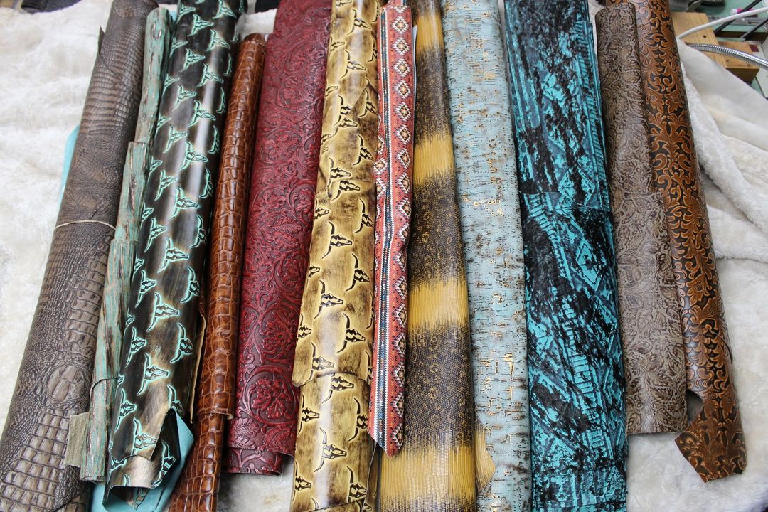 Various long, textured leather pieces in shades like turquoise, brown, and red are laid out.