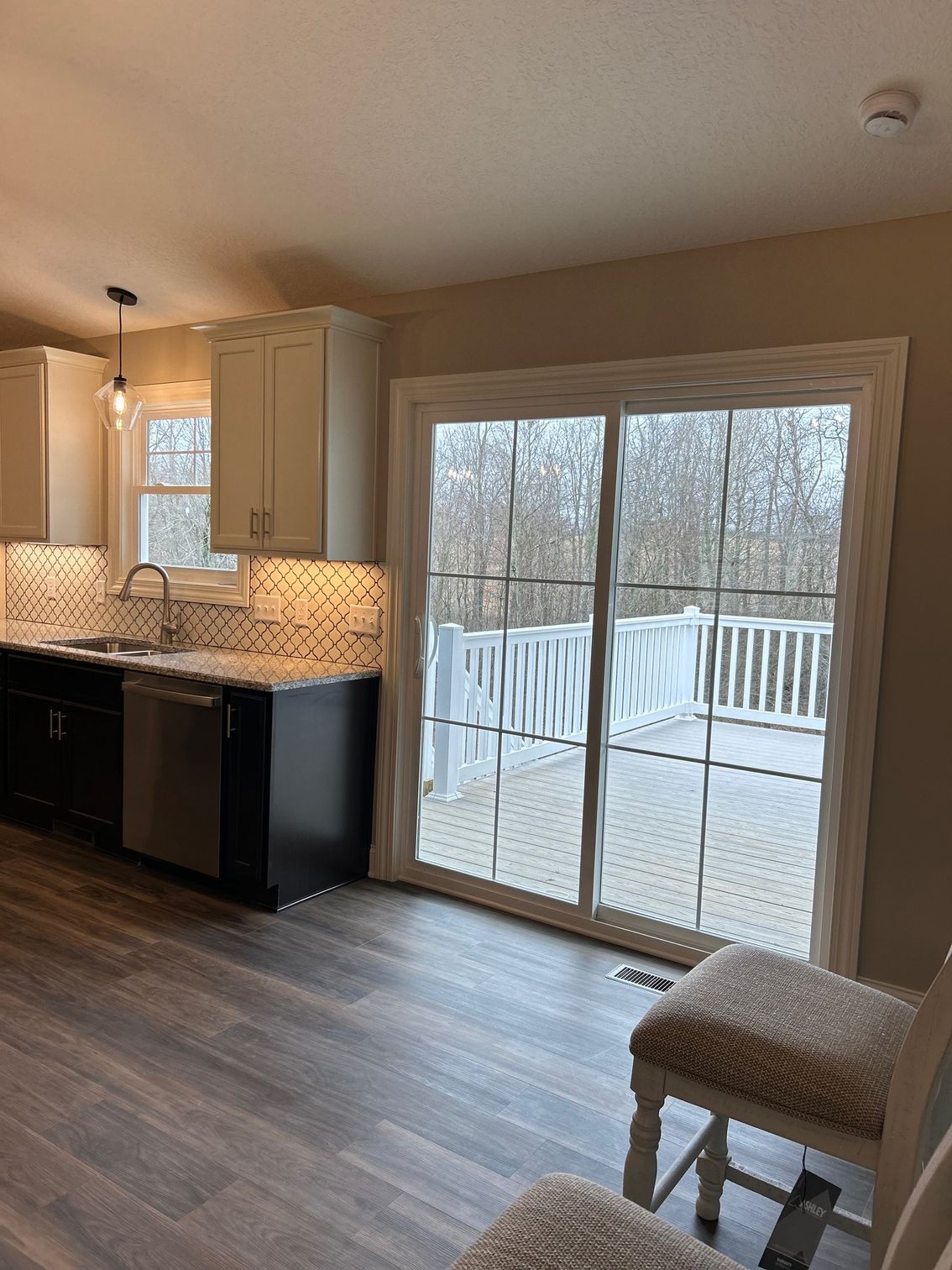 A kitchen with a sliding glass door leading to a deck.