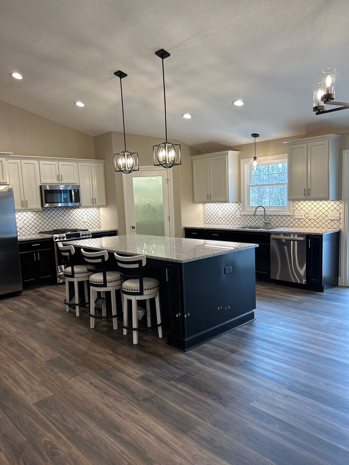 A kitchen with stainless steel appliances and a large island.