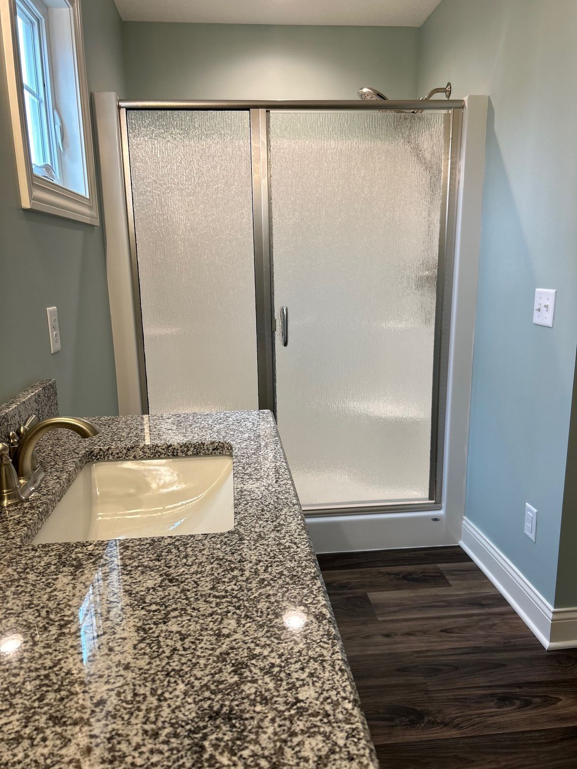 A bathroom with a sink and a walk in shower.