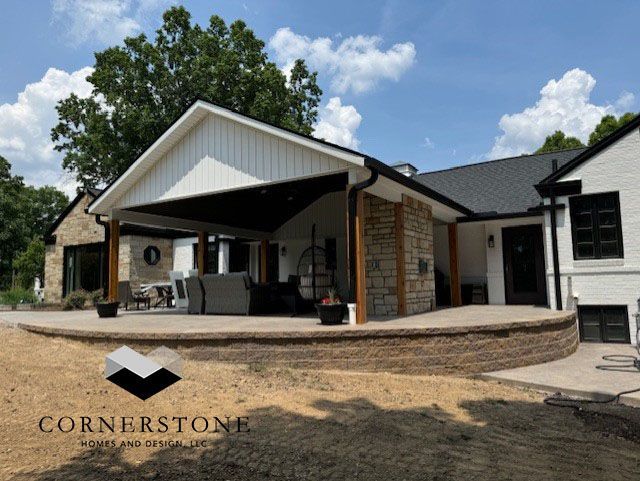 A house with a covered patio and a cornerstone logo