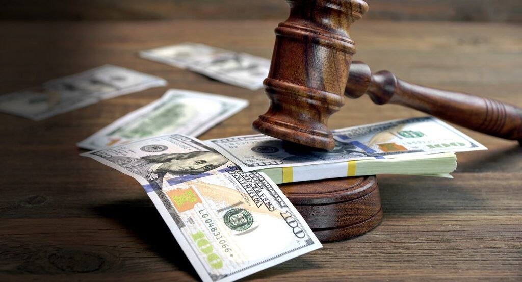 A judge 's gavel is sitting on top of a pile of money.
