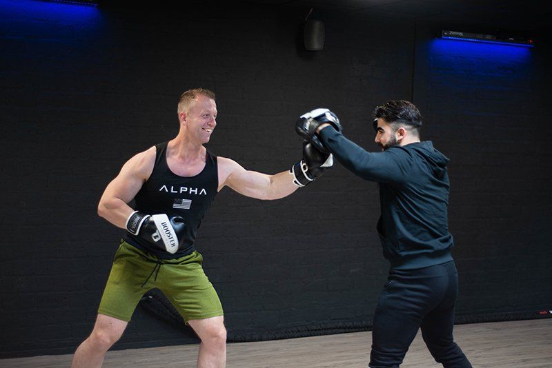 Twee mannen zijn aan het boksen in een sportschool.