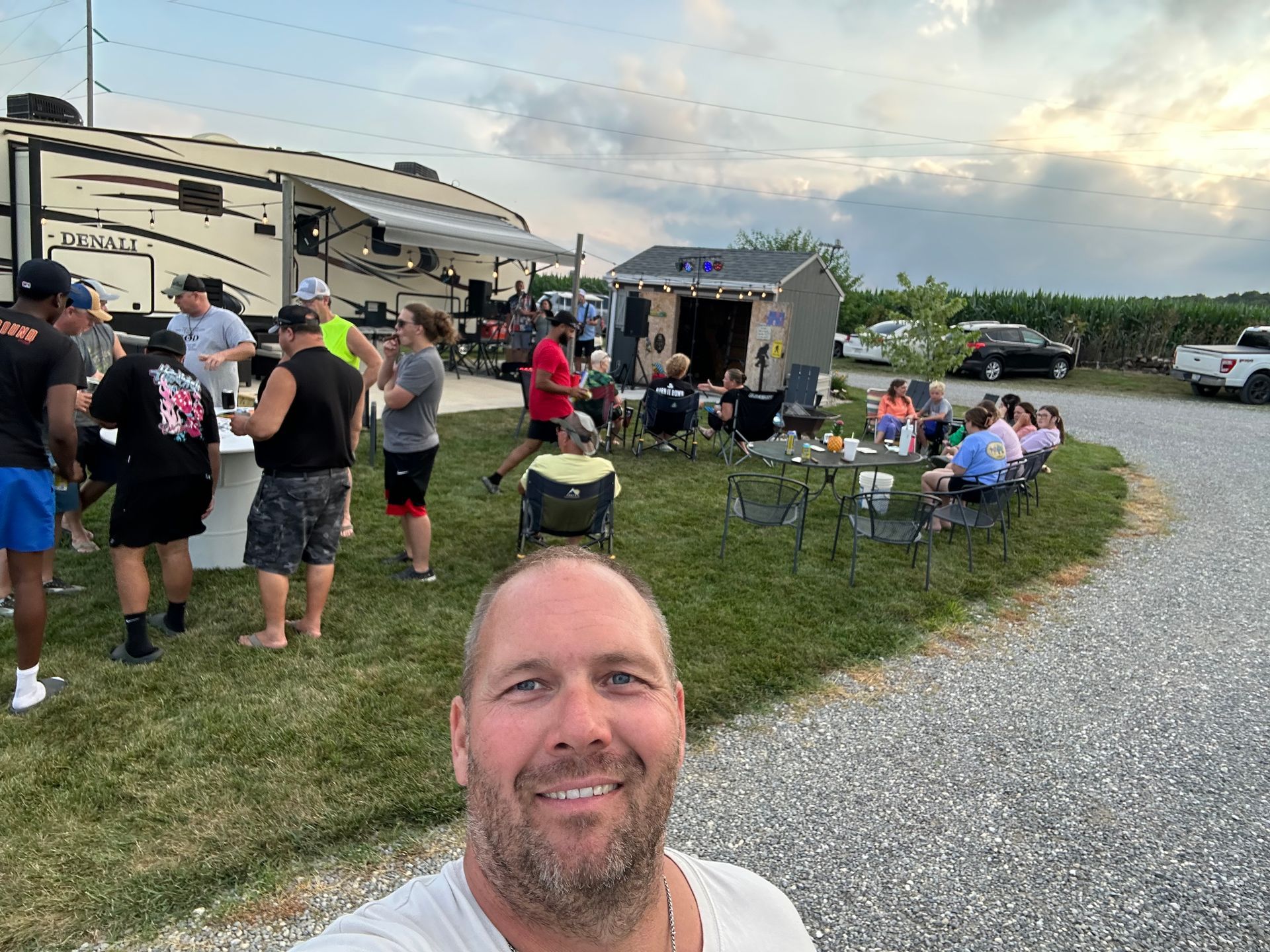 A man is taking a selfie in front of a group of people. | Chickasaw Garage